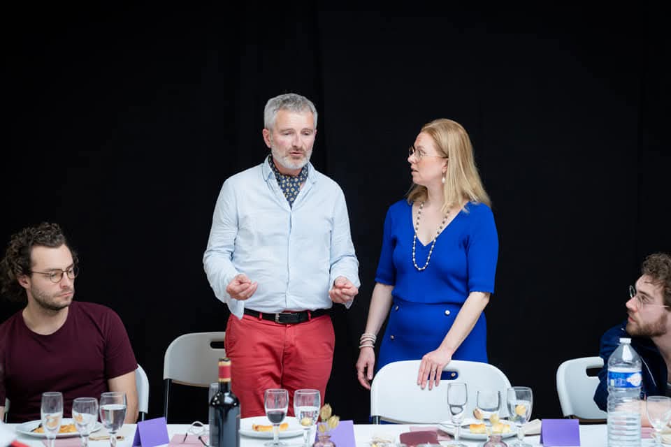 Comedien montrant un exemplaire de Festin a table