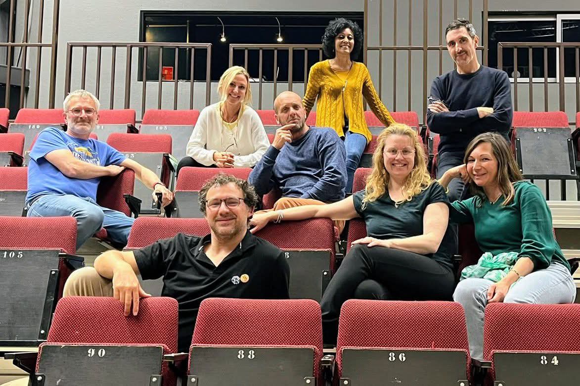 Photo de groupe des Armateurs assis dans les gradins d'une salle