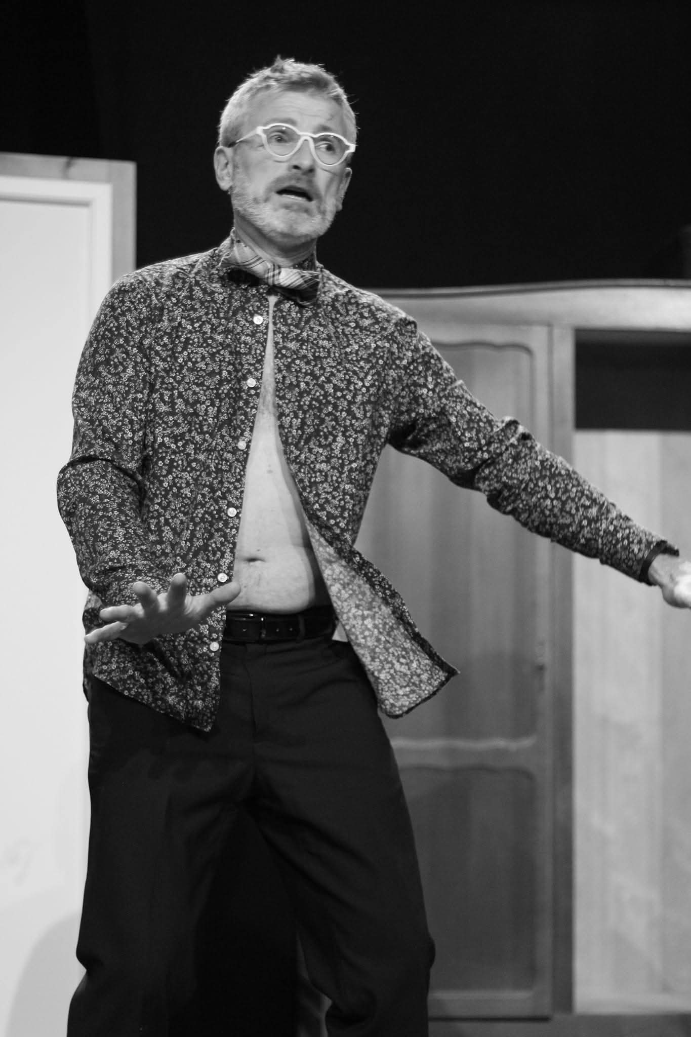 Comedien en mouvement devant le decor de A vau-l'eau Vaudeville