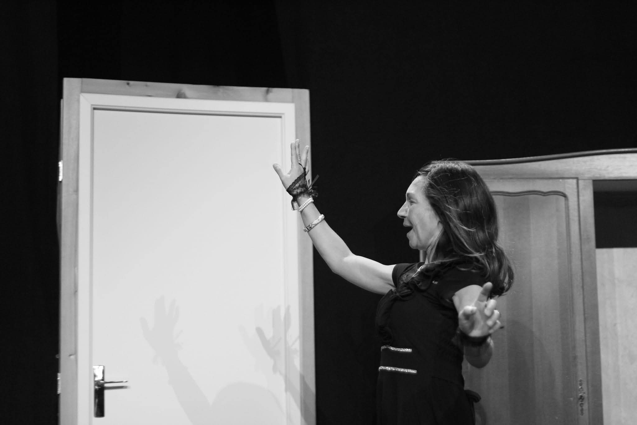 Comedienne levant les bras sur scene dans A vau-l'eau Vaudeville