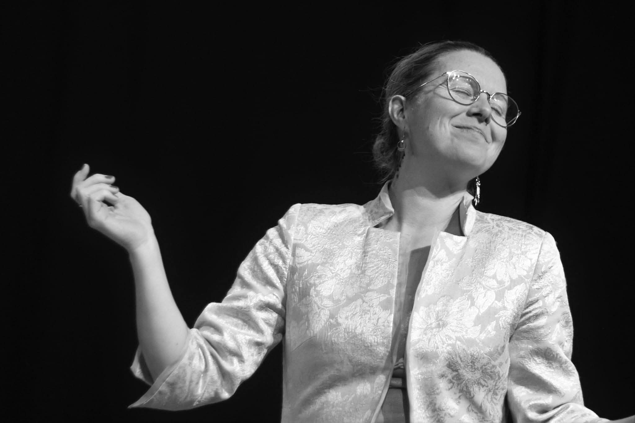 Comedienne en veste claire sur scene dans A vau-l'eau Vaudeville